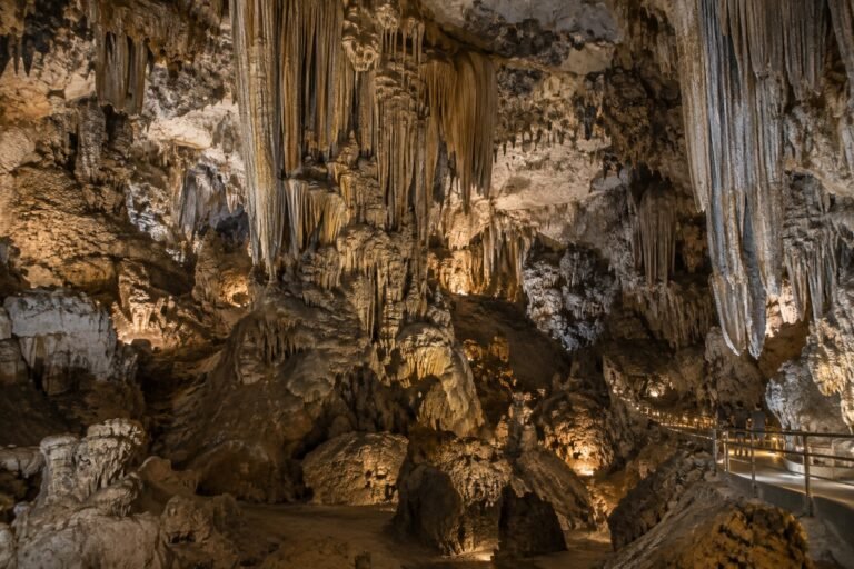 Ilustración IA de una cueva de caliza con grandes estalactitas y pasarela