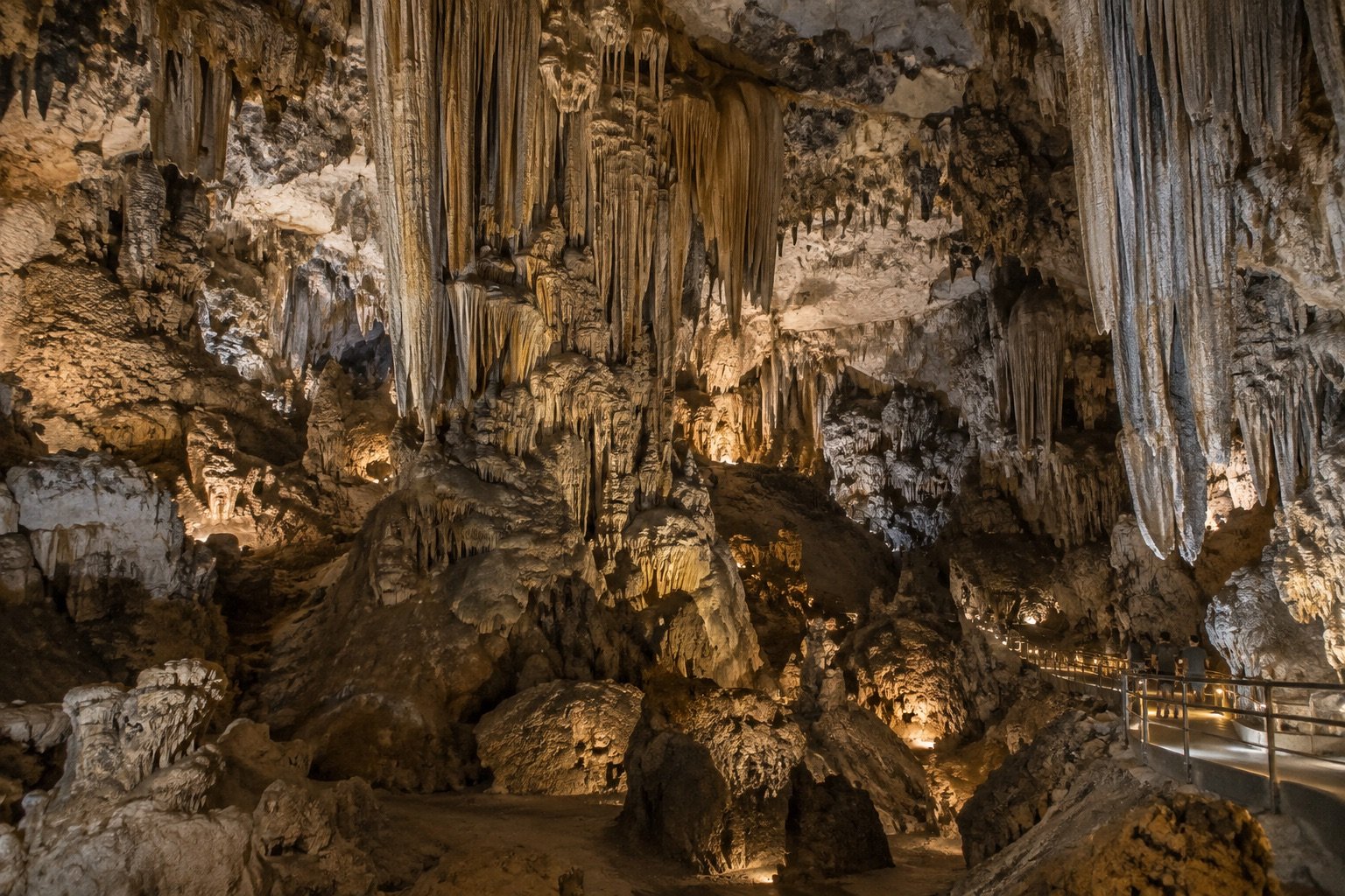 Ilustración IA de una cueva de caliza con grandes estalactitas y pasarela
